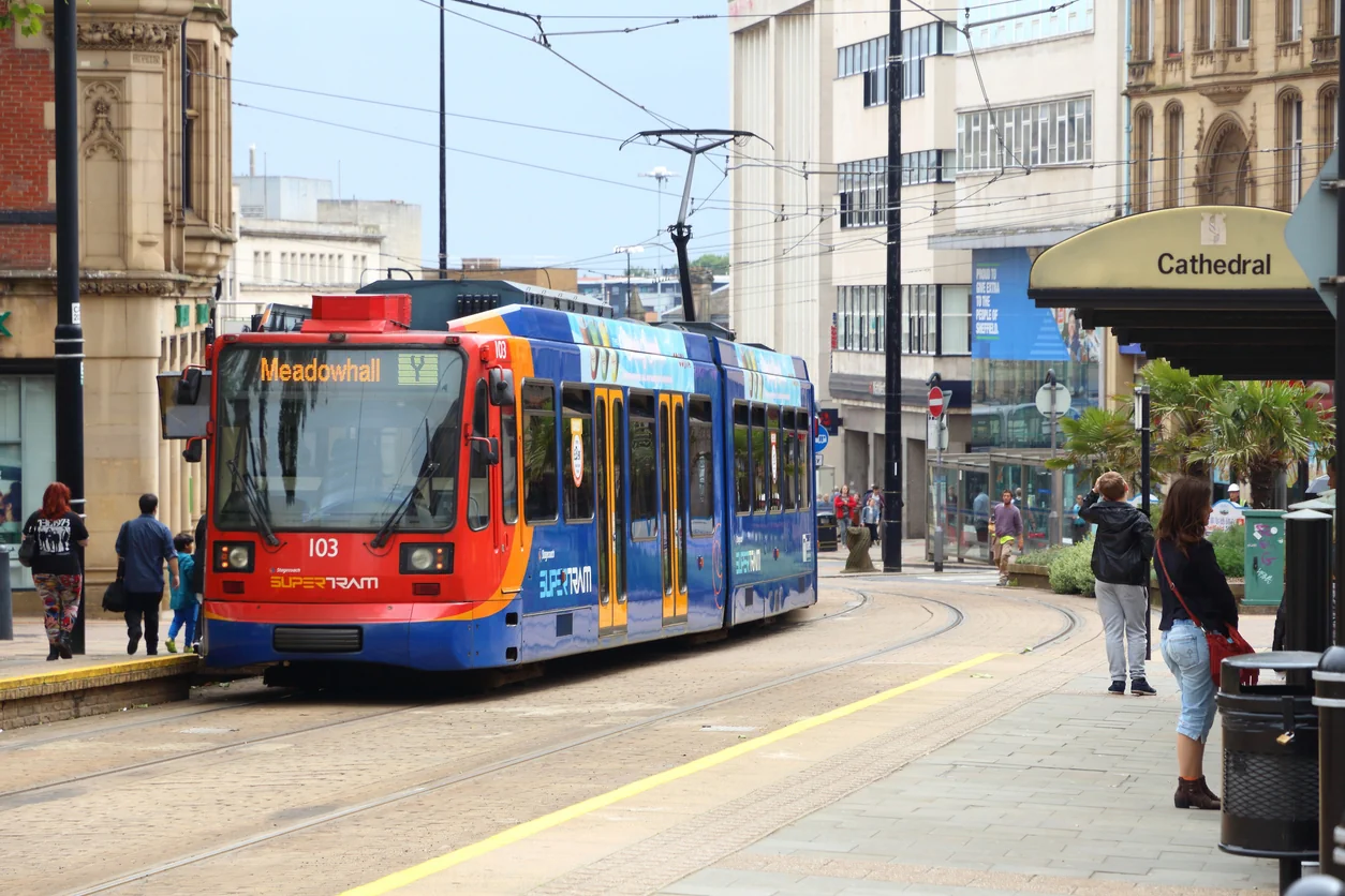 City centre scene featuring the Sheffield Supertram operating through a busy urban area. The image highlights the importance of local infrastructure, public transport and connectivity in attracting tenants to rental properties. Strong transport links, access to employment hubs, shopping destinations and city amenities help make Sheffield an appealing location for residents and buy to let property investors. Sheffield Supertram in city centre highlighting transport links and infrastructure that attract tenants to rental properties