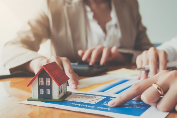 Close up hand of businesswoman signing contract Insurance protecting house.