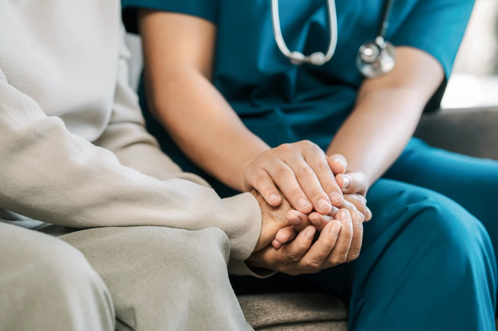 Assisted Living UK Care Support Guide Healthcare professional providing compassionate support by holding an older persons hand in assisted living UK property investor guide