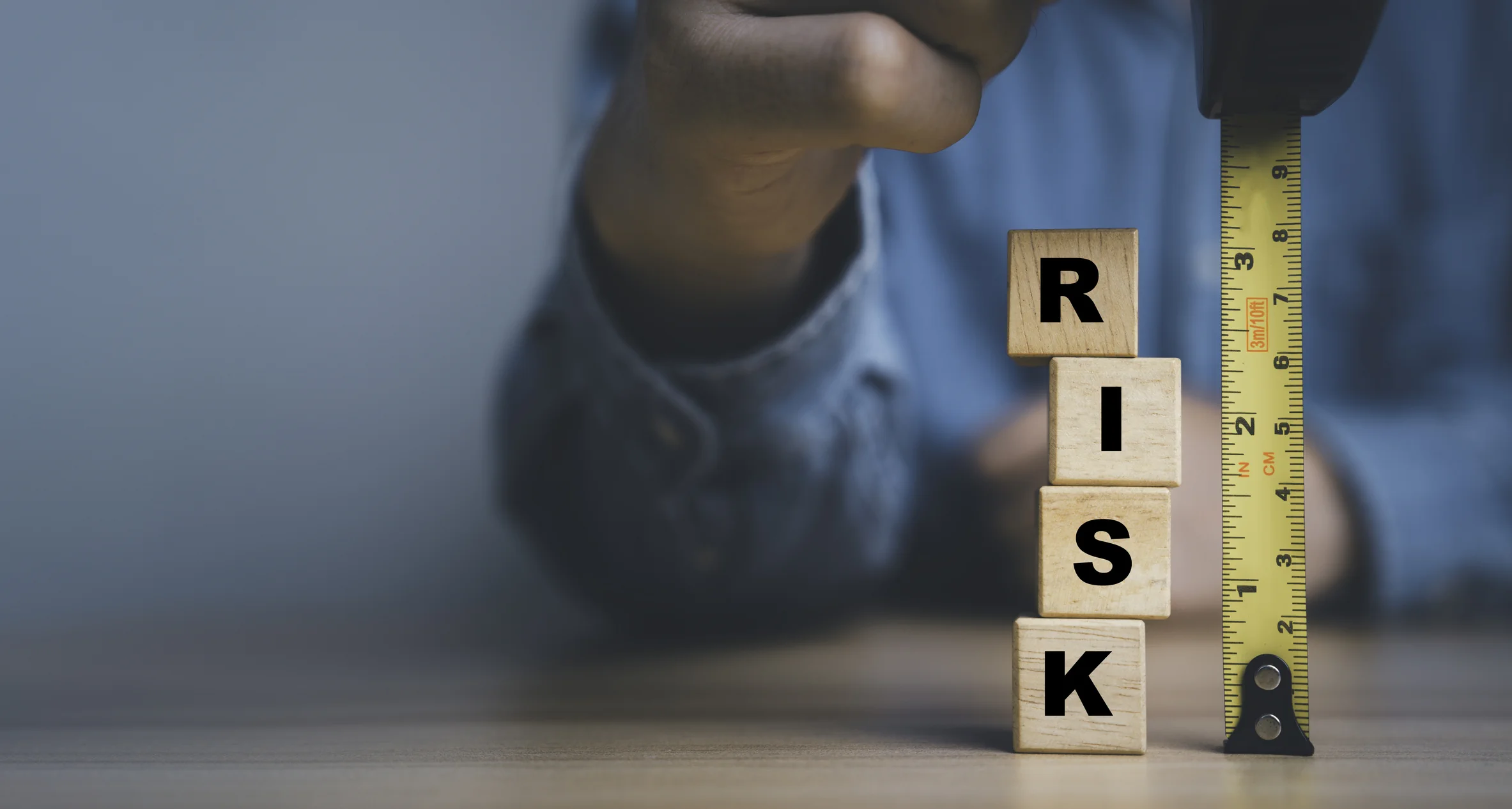Wooden risk blocks beside measuring tape representing financial risks and limitations of UK passive property income