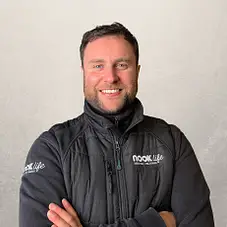 Professional man in branded jacket smiling with arms crossed representing property furniture packages for investors service team
