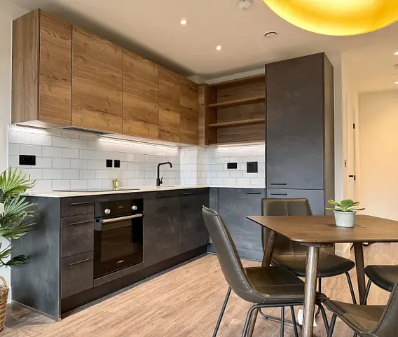 Modern kitchen with wood cabinets dining table and chairs in apartment showing property furniture packages for investors