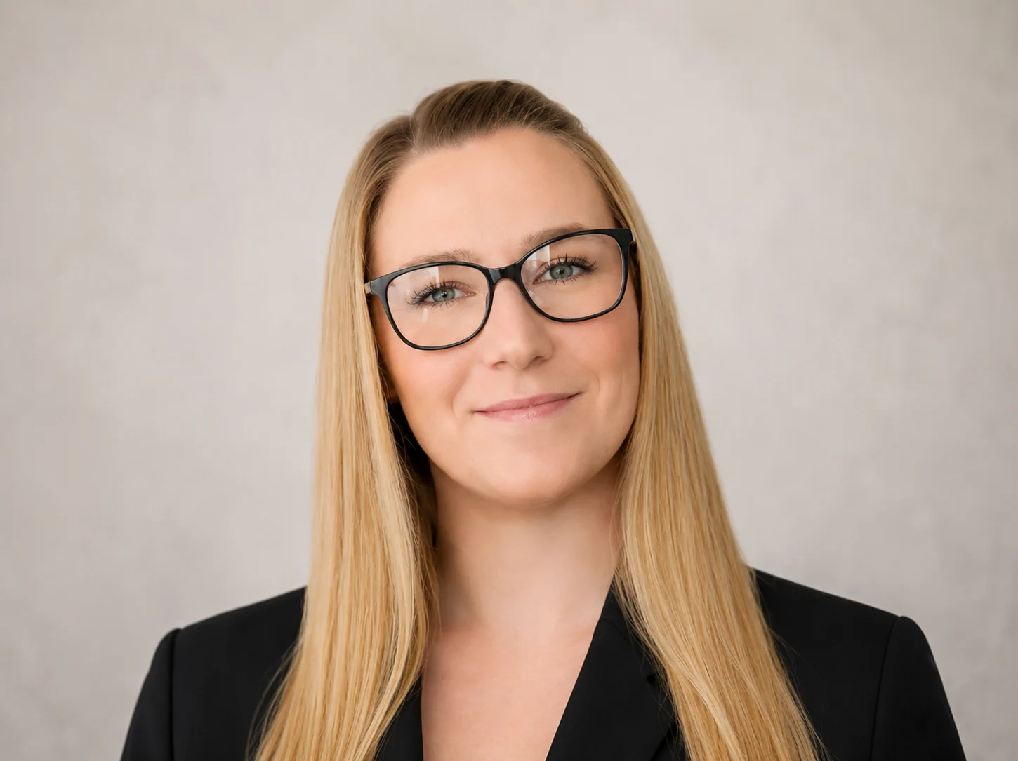 Professional woman with glasses smiling representing operations and marketing role in property investment business support team