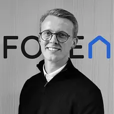 Professional man in office smiling representing property lettings and management services UK for landlords and investors