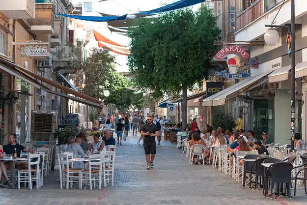 Busy Cyprus street with cafes and restaurants showing everyday cost of living and operating costs for property investors