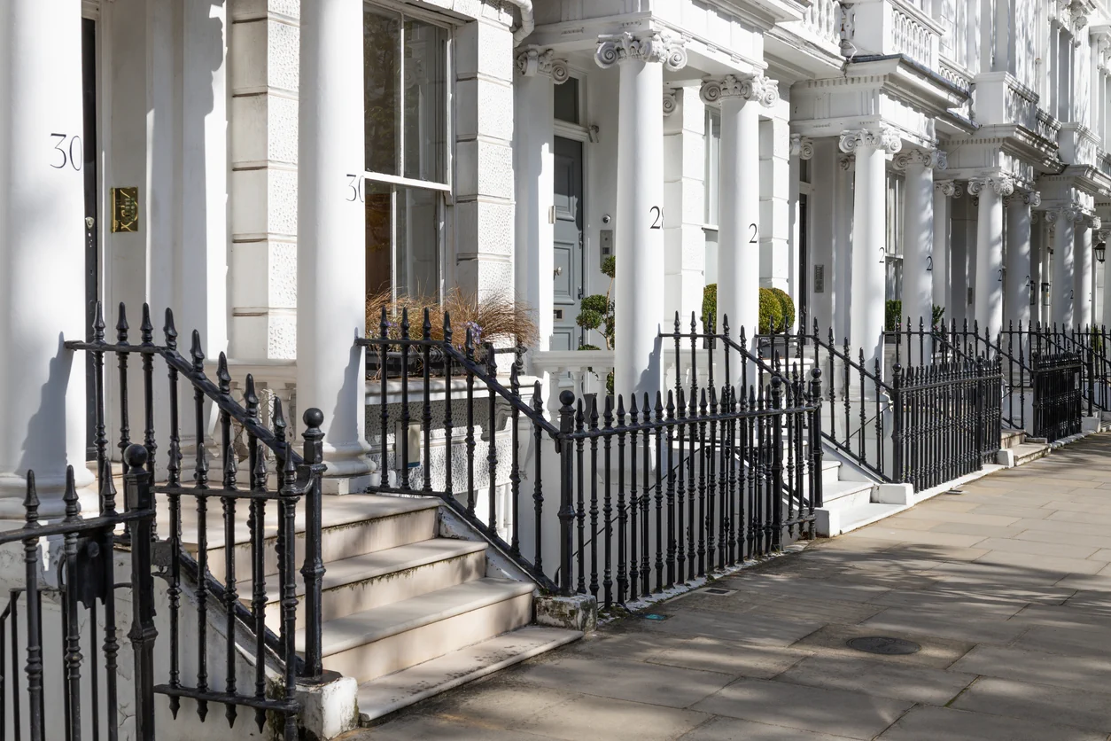 Row of elegant UK townhouses with white facades illustrating property developments and suitability for different investors