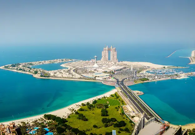 Aerial view of Abu Dhabi waterfront development with island residences and road access showing property investment opportunities
