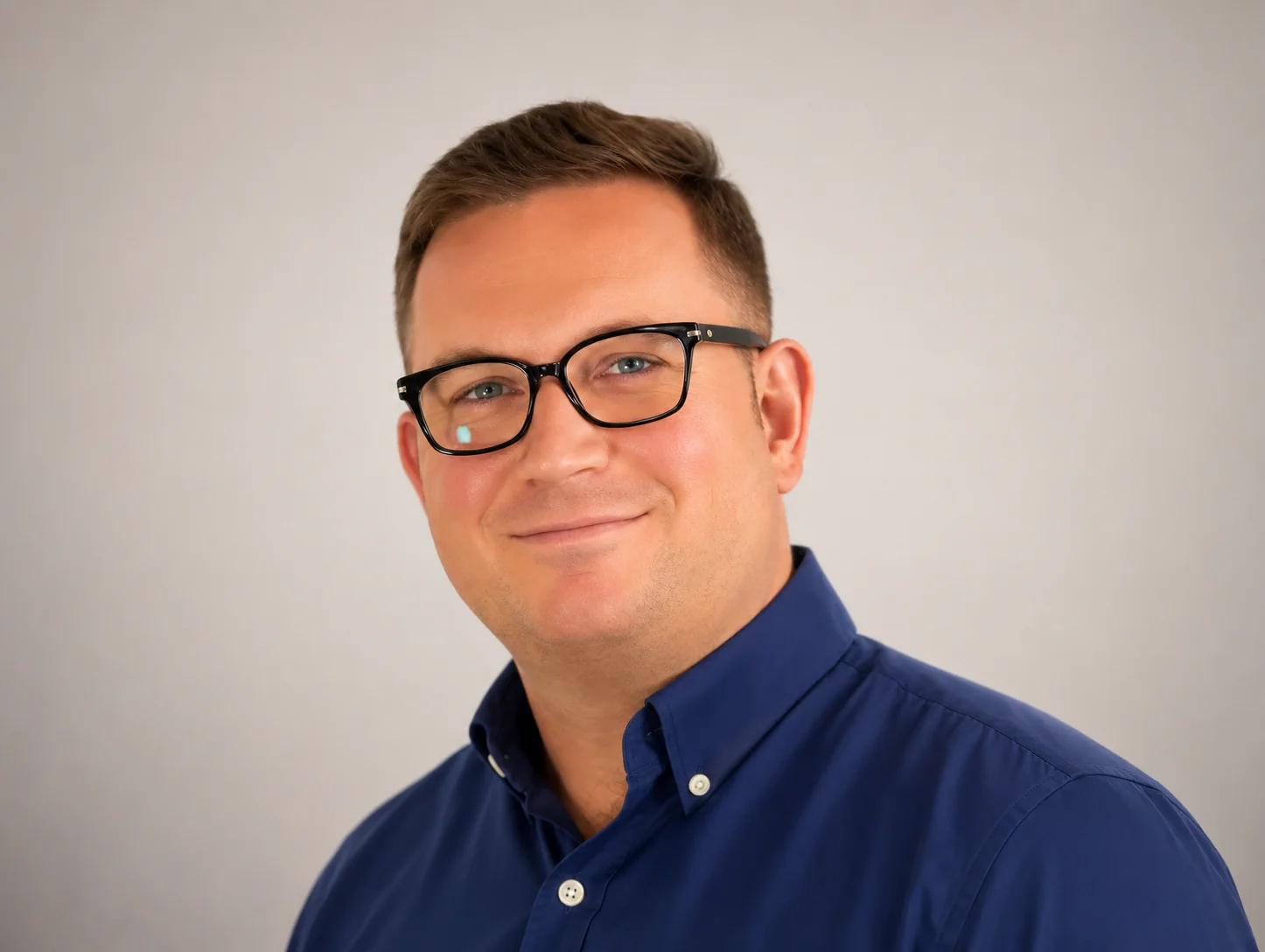 Professional man wearing glasses smiling representing property investment director offering buy to let advice and investor support