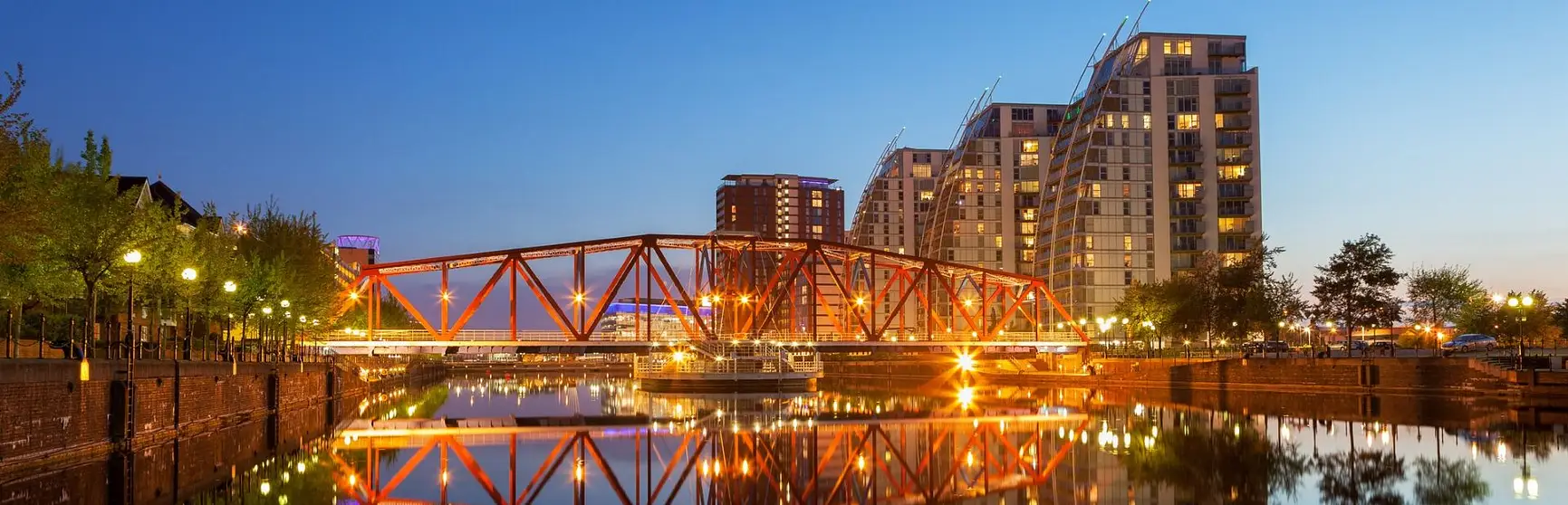 Modern apartments and a red iron bridge over Manchester Canal in Salford Quays, Greater Manchester, England
