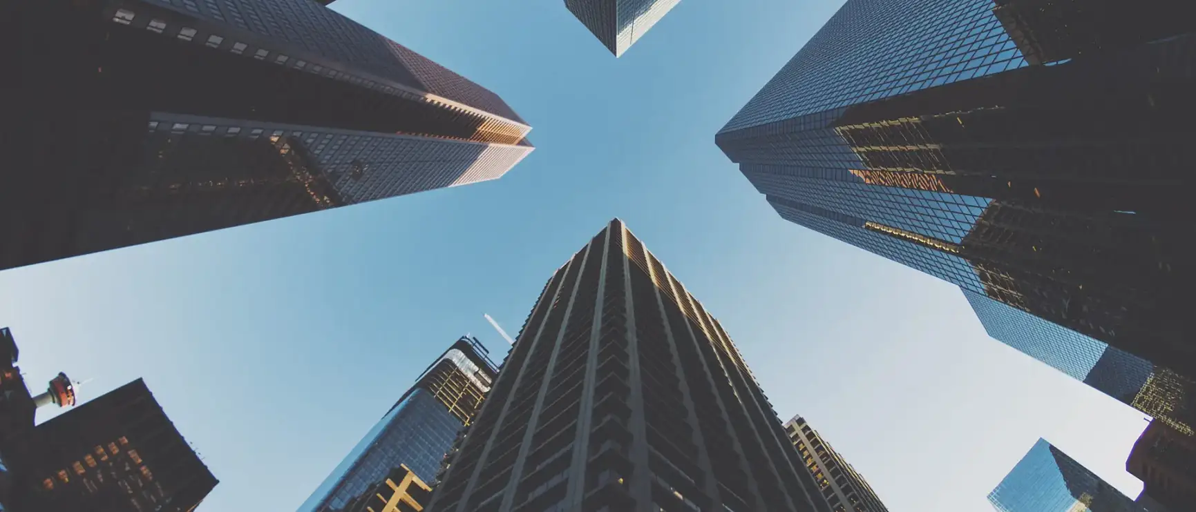 Upward view of modern city skyscrapers representing how 365 Invest supports property investors with growth and opportunity