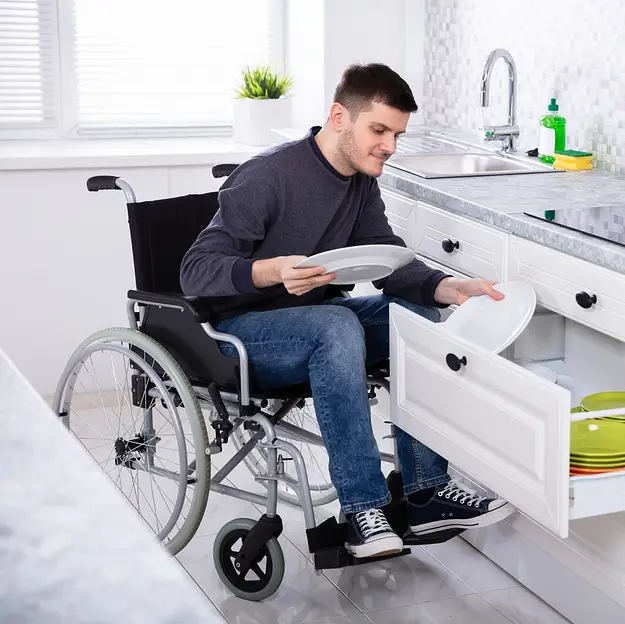Man in wheelchair using accessible kitchen representing assisted living investments with 365 Invest and inclusive housing solutions