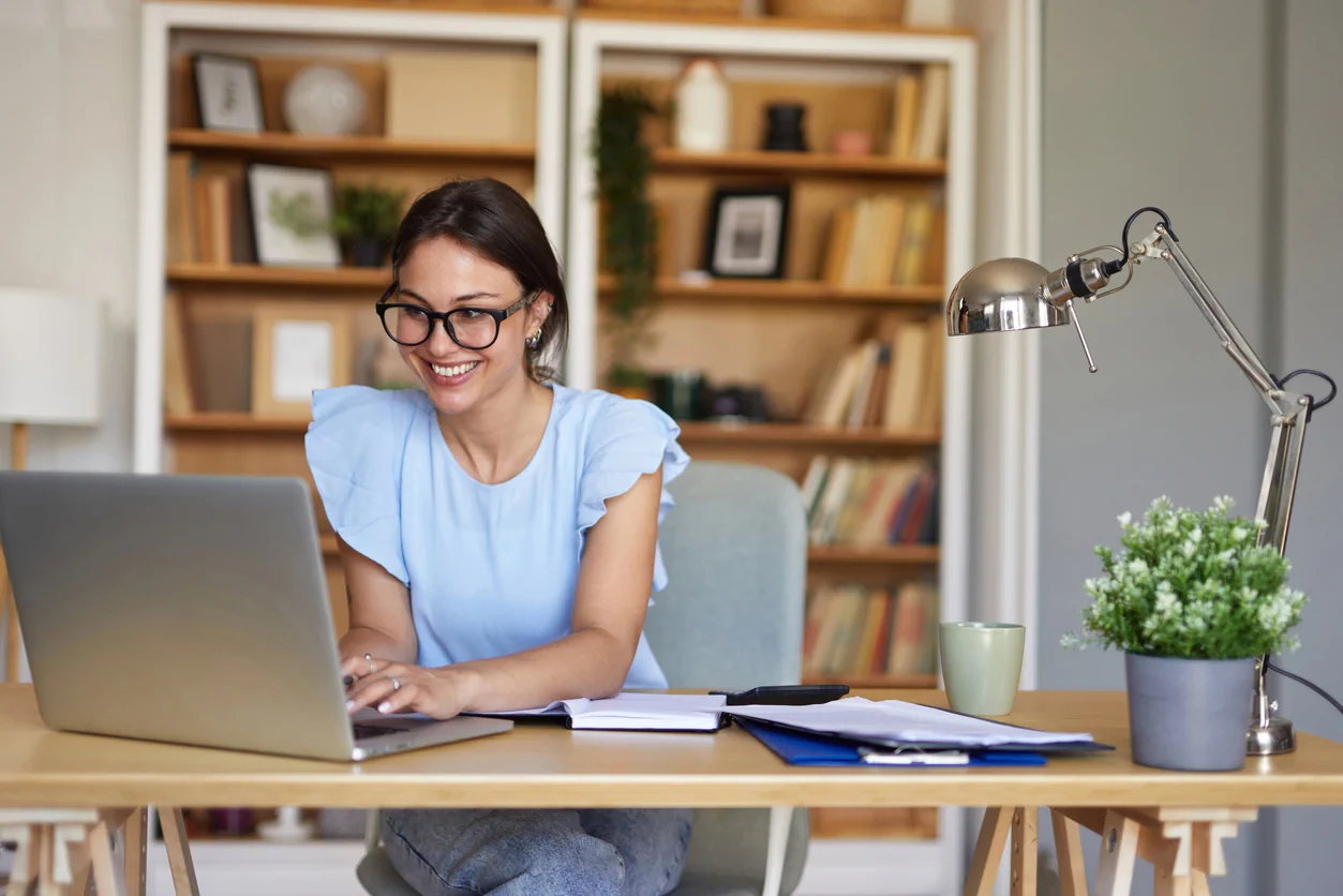 Woman working on laptop at home office researching buy to let property investment and managing rental property decisions